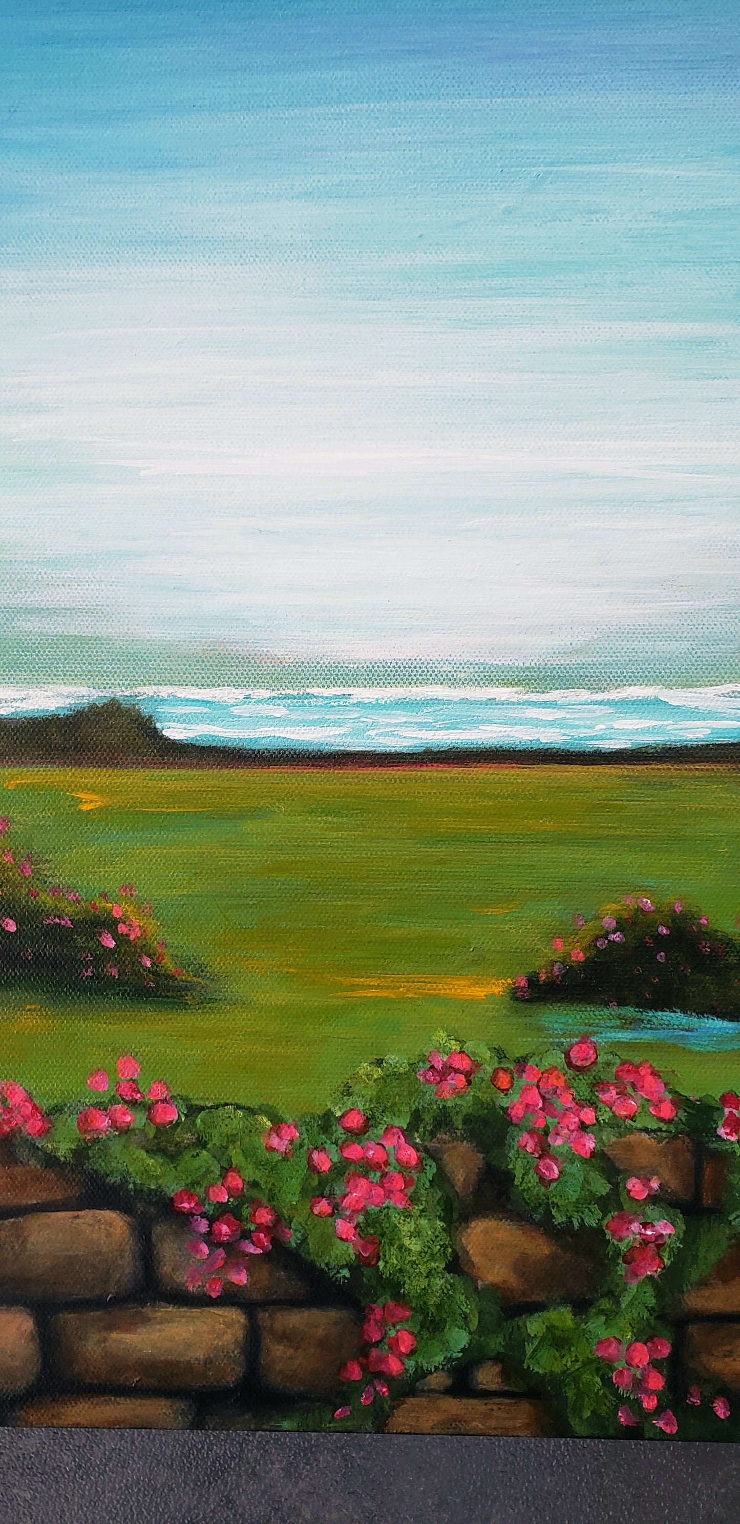 Painting of a garden with pink flowers and a stone wall, featuring a blue sky and green field.
