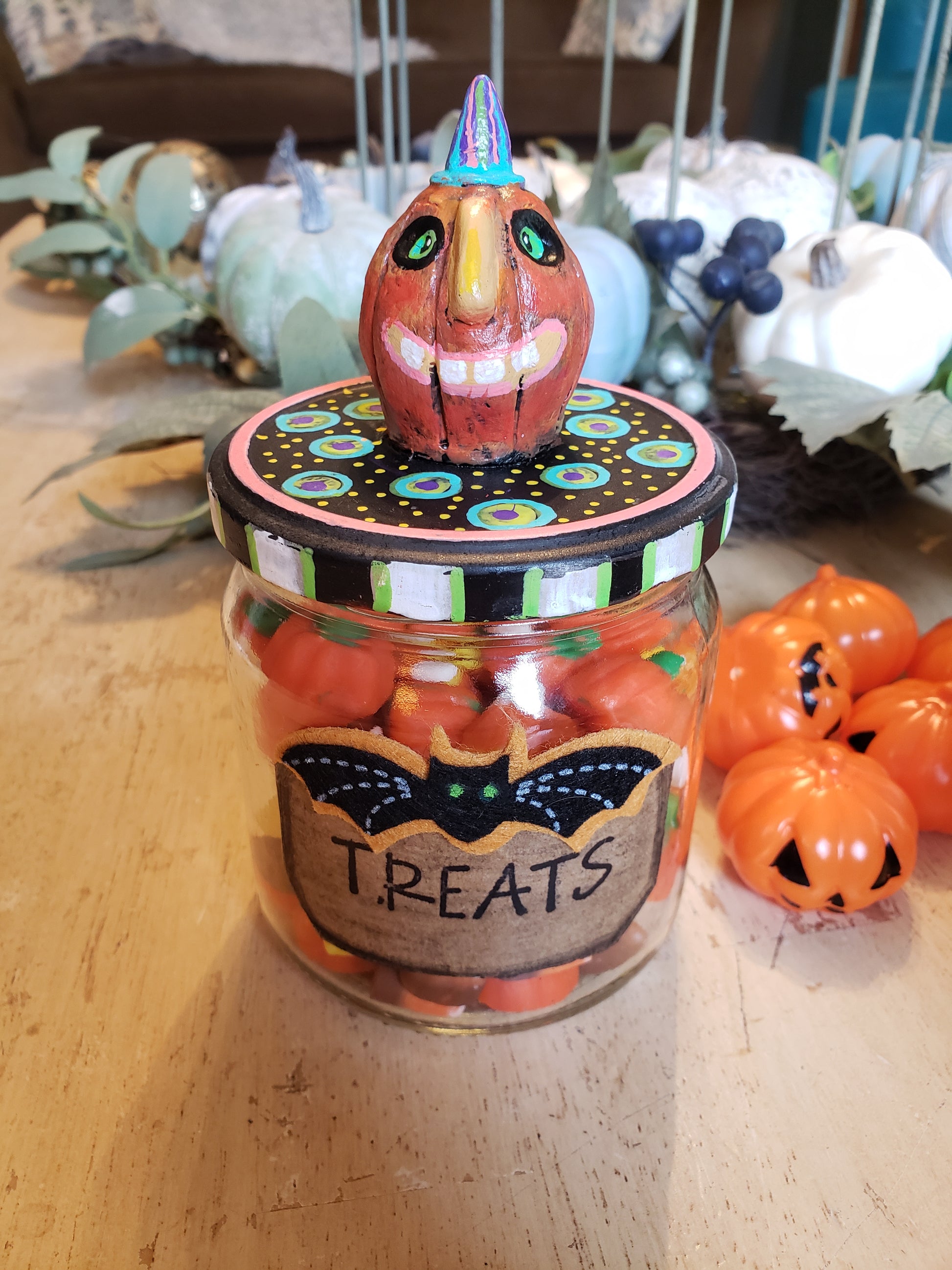 Halloween-themed candy jar with decorative lid on a wooden surface