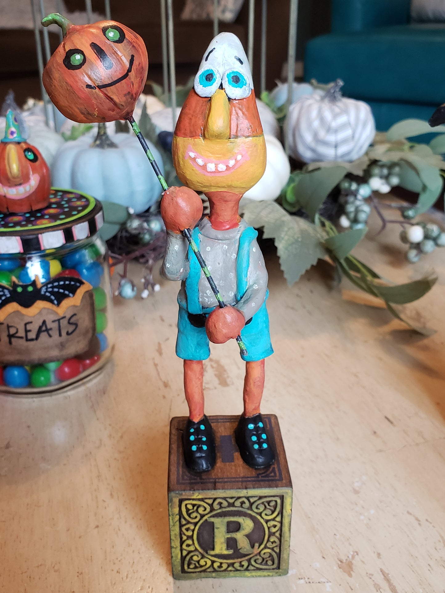 Colorful paper clay halloween figure  standing on a wooden letter block. 