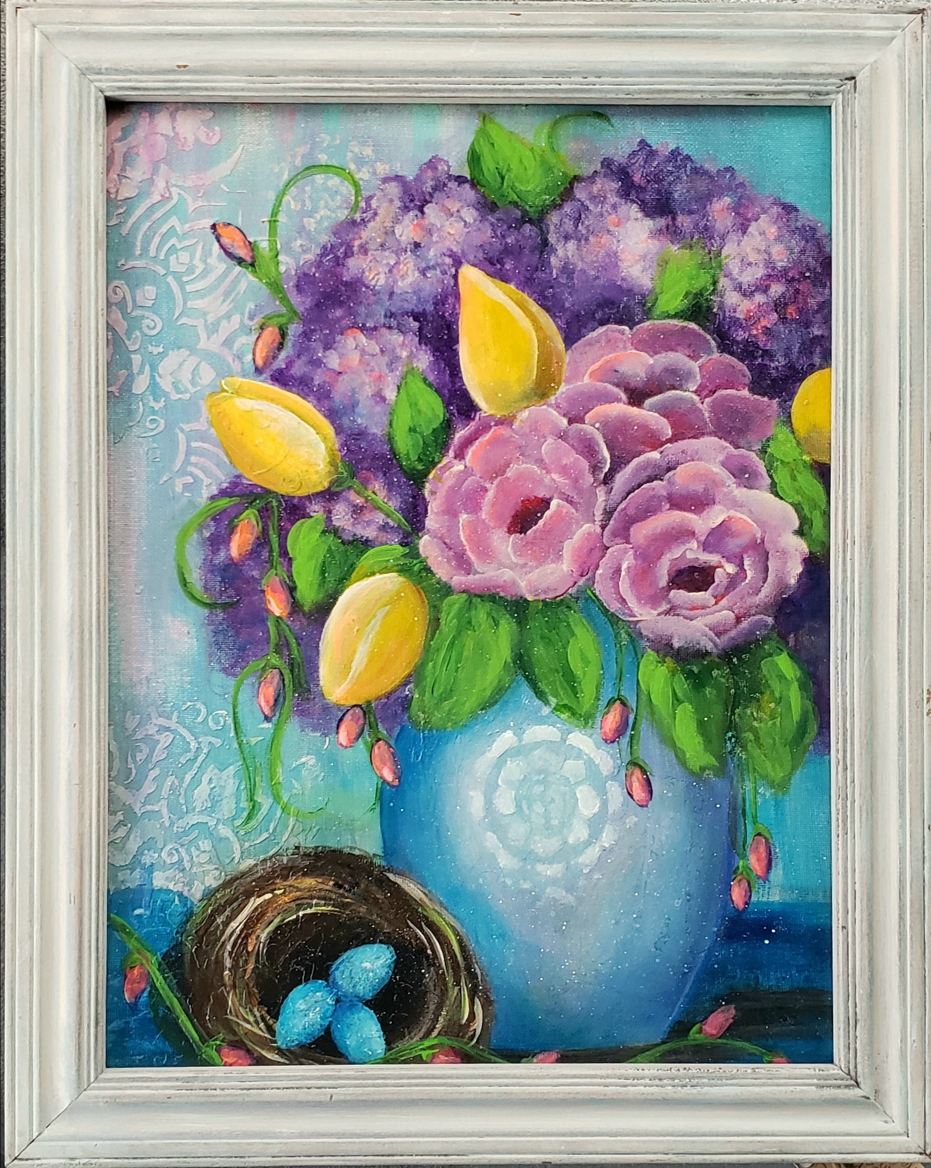 Framed artwork of a bouquet of flowers with a blue vase and nest on a textured background