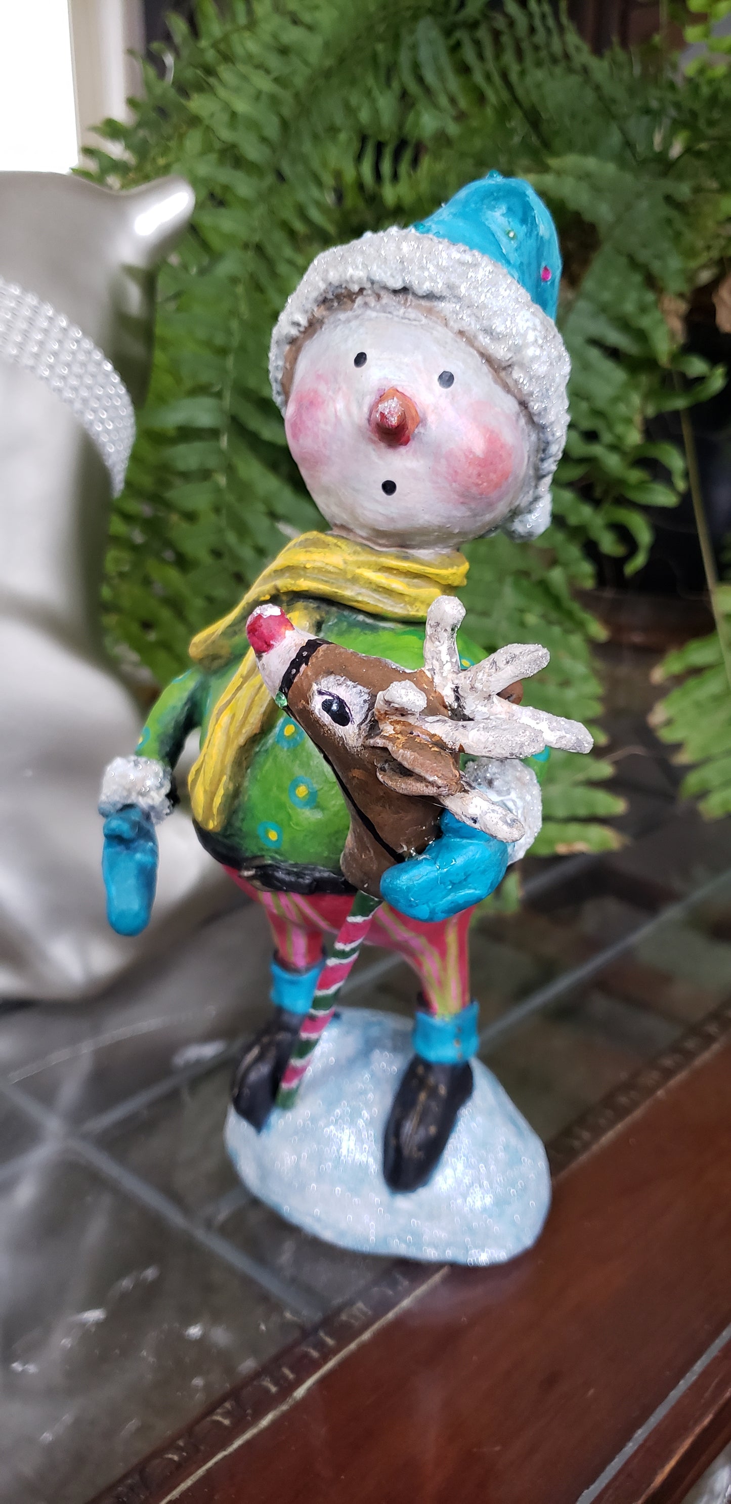 Decorative paper clay figurine of a snowman with a reindeer 