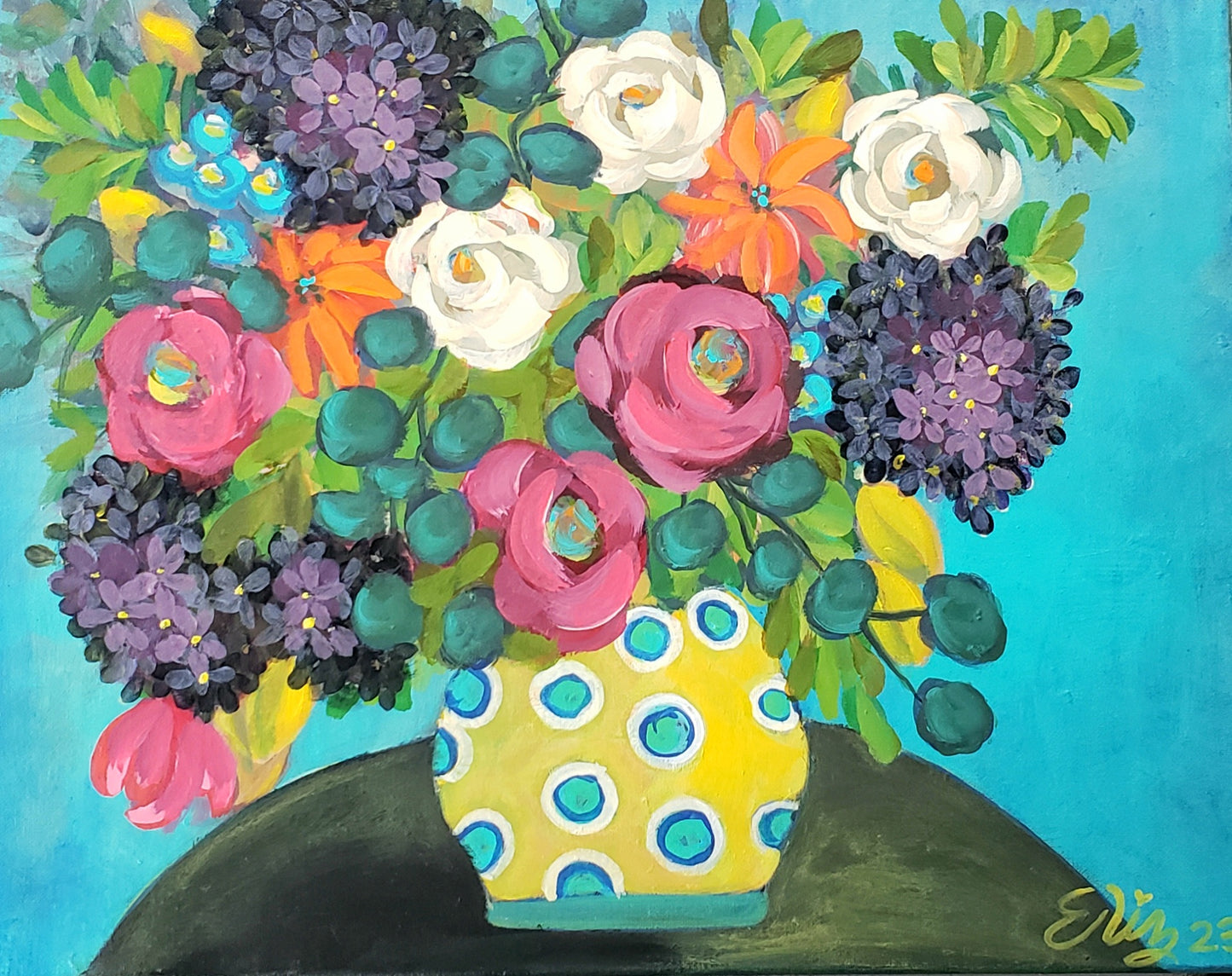 Colorful floral arrangement in a polka dot vase on a solid background