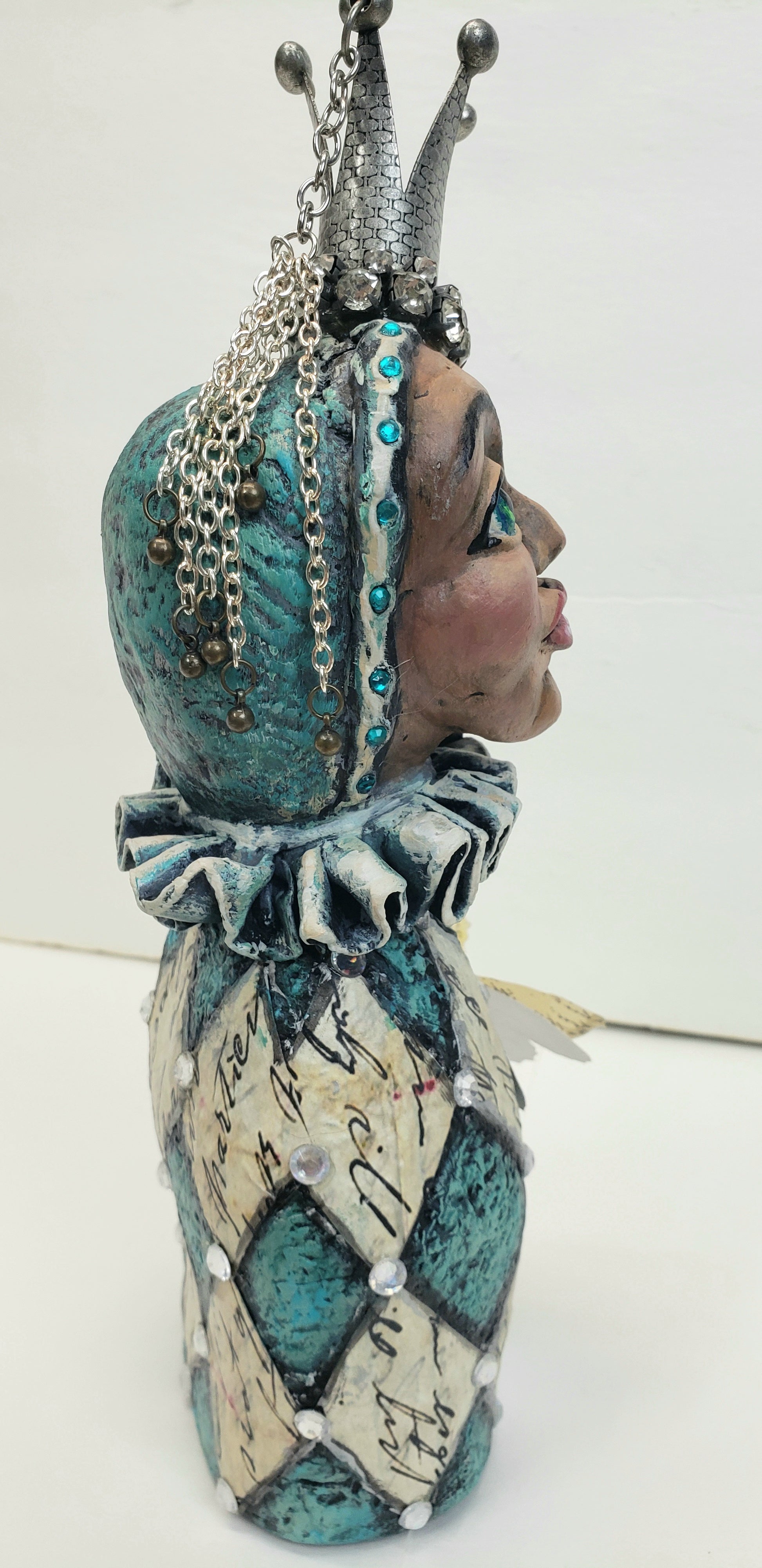 Decorative jesture figurine with intricate design and metal crown and rhinestones teal and antique white with a paper butterfly
