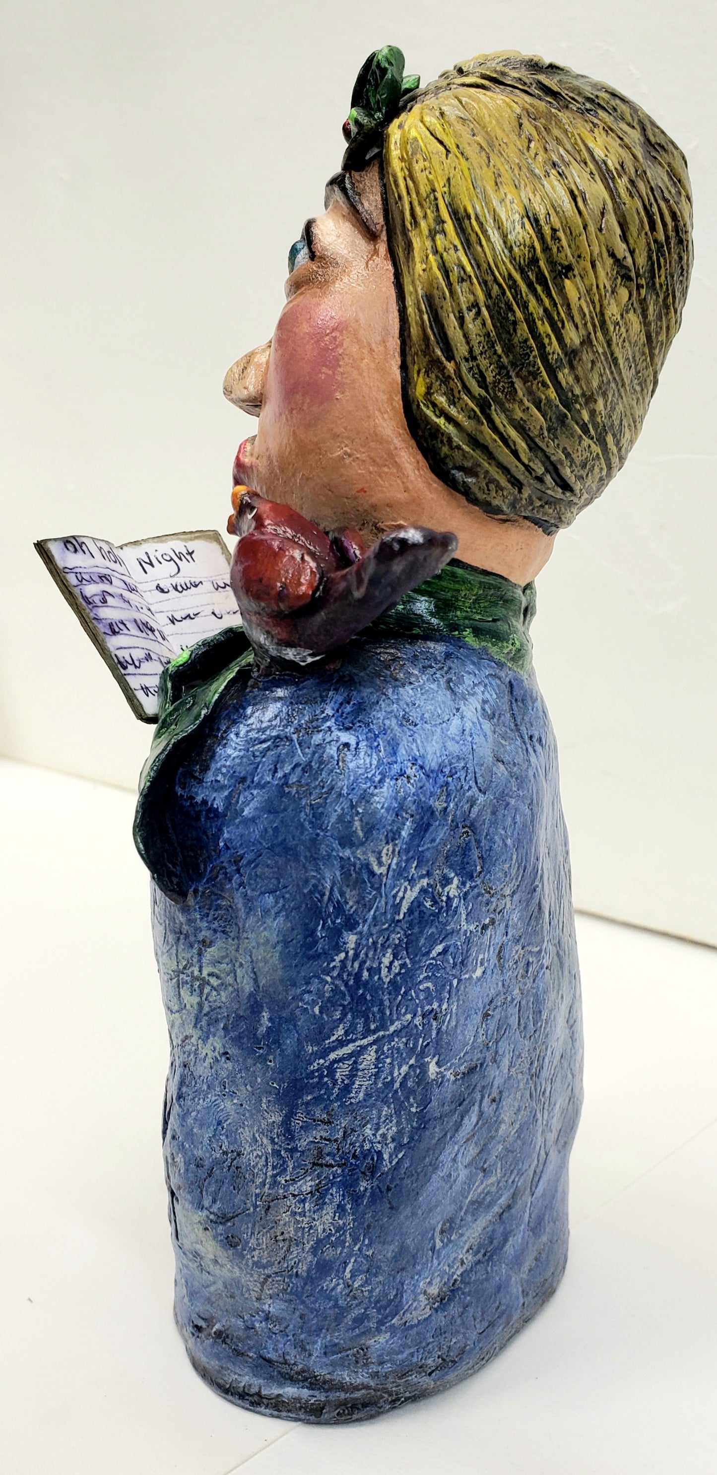 paper clay christmas carol doll holding a christmas carol book with a bird on her shoulder handmade christmas decoration