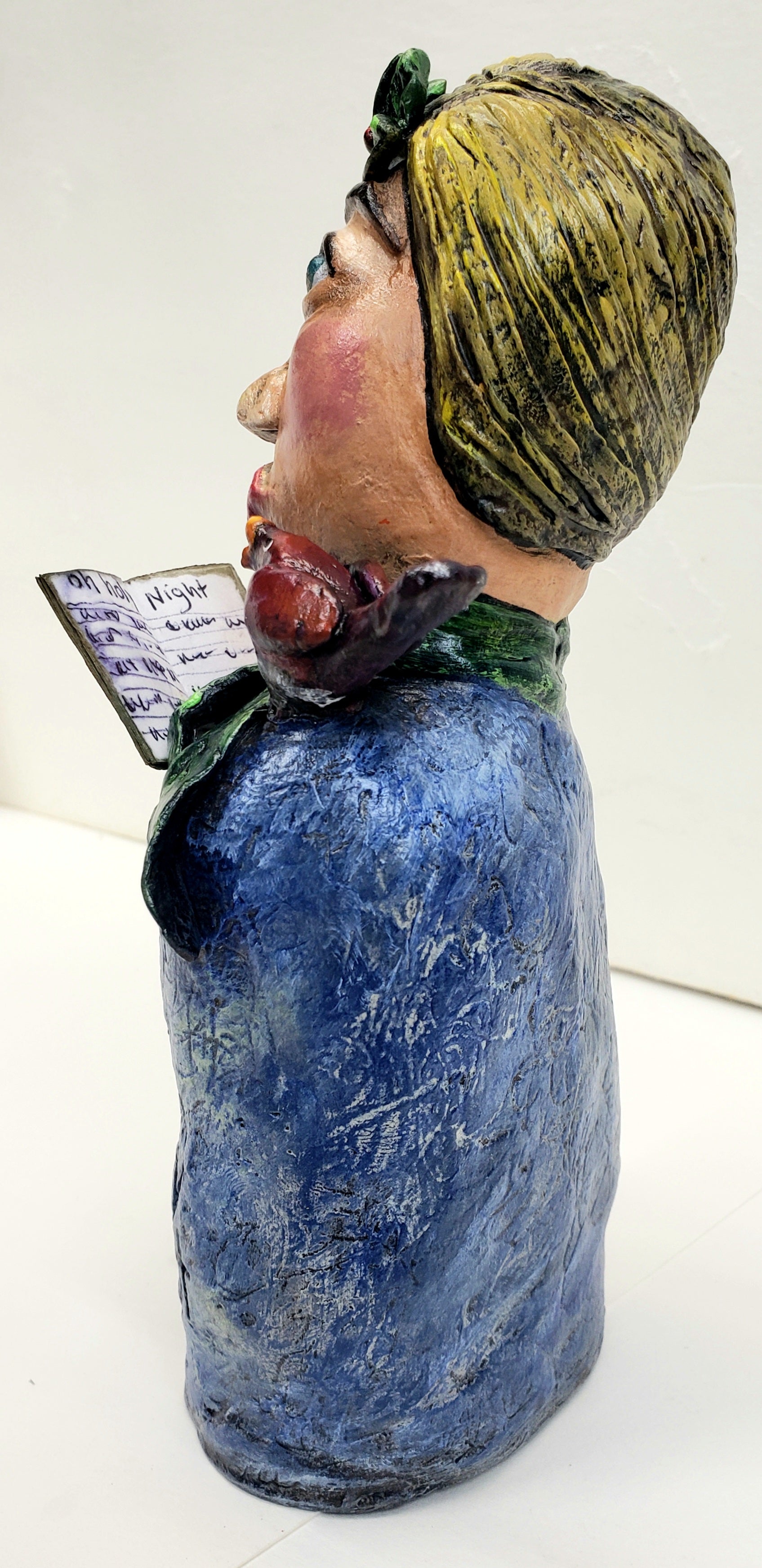 paper clay christmas carol doll holding a christmas carol book with a bird on her shoulder handmade christmas decoration