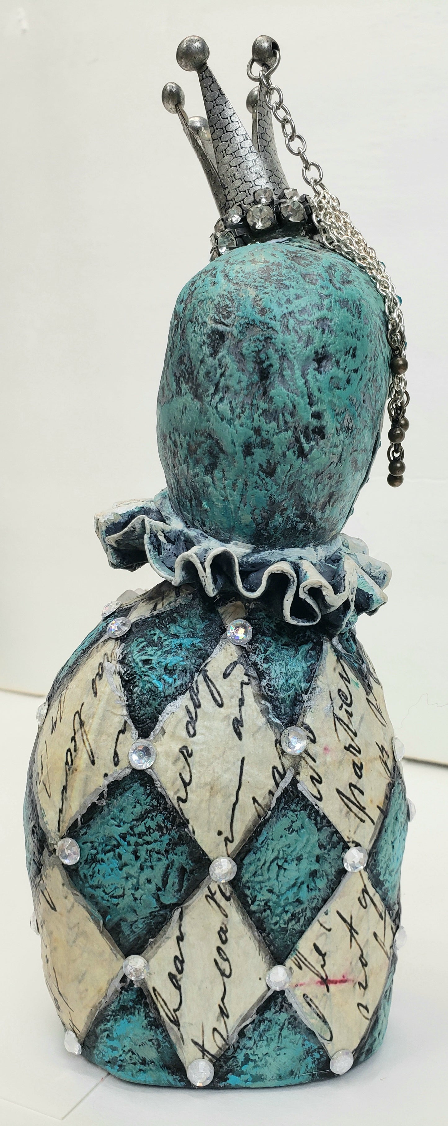 Decorative jesture figurine with intricate design and metal crown and rhinestones teal and antique white with a paper butterfly