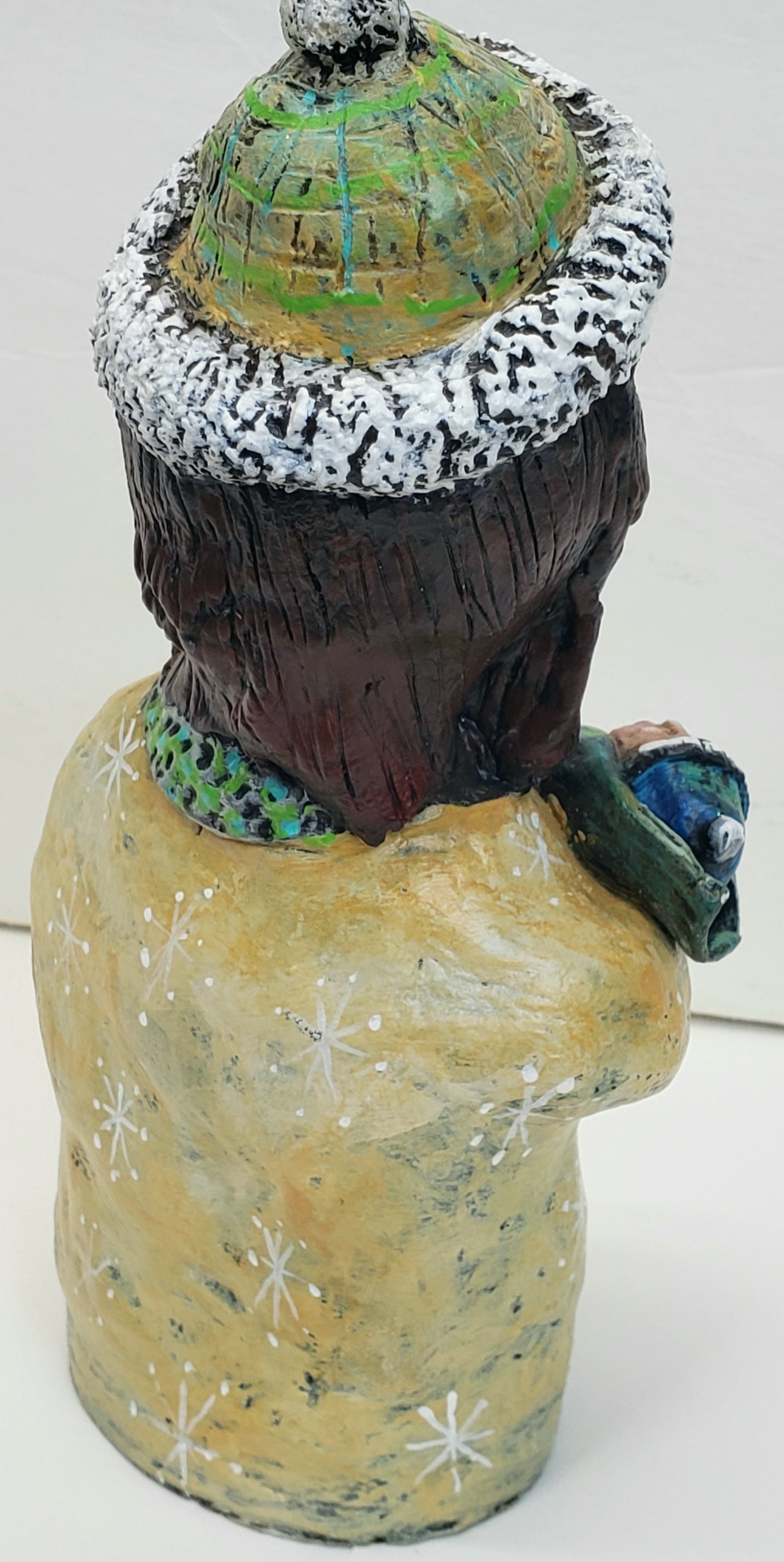 Decorative paper clay figurine of a woman holding a baby with text 'Baby It's Cold Outside' standing Christmas decoration