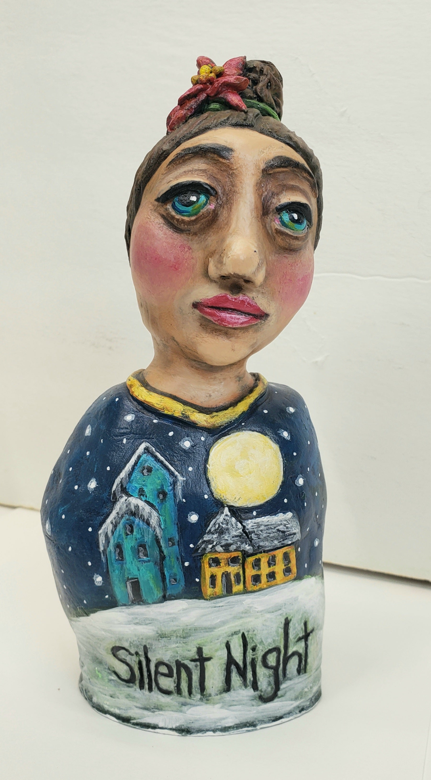 Ceramic figurine with a snowy village design and 'Silent Night' text on a white background